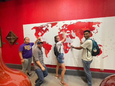 Four people in front of map.